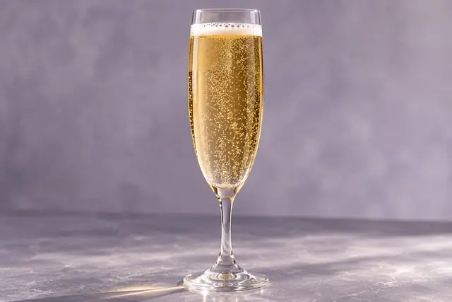 Flûte remplie d’une boisson ambrée aux bulles fines